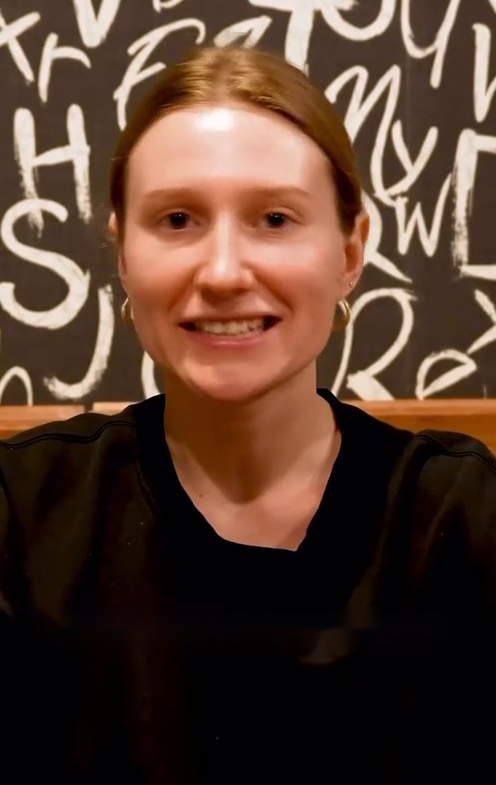 Chat Up hocası gülümsüyor, arkasında elle çizilmiş harflerden bir duvar var